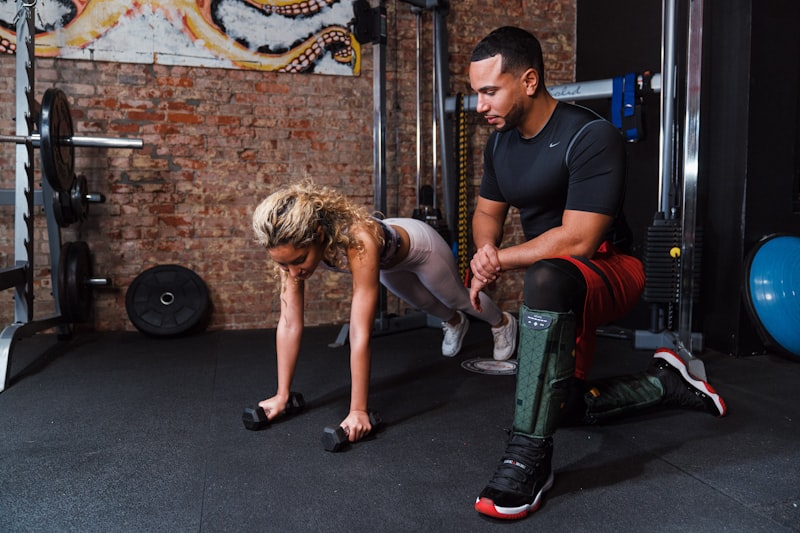 a man helping another man do push ups