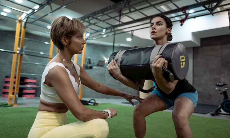A man and a woman doing squats in a gym