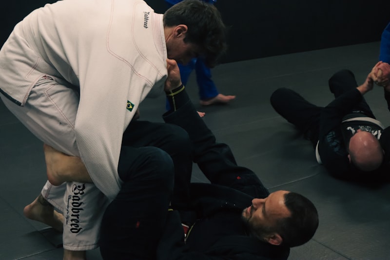 a man in white shirt and black pants standing over another man in black pants