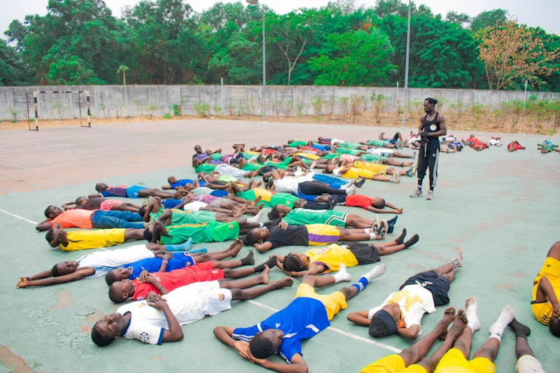 Group of young men lying on the ground outdoors.