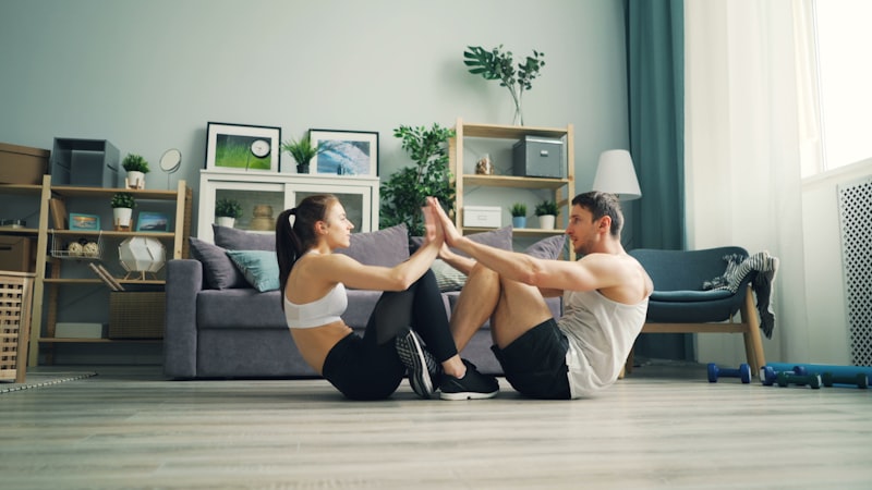 a man and woman sitting on the floor in a living room