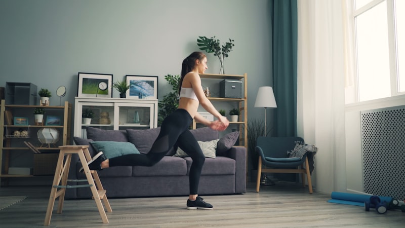 a woman in a white top and black leggings in a living room