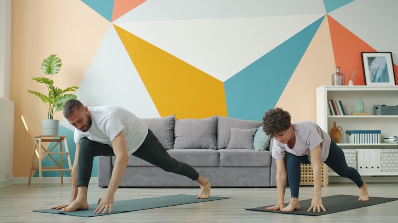 Couple practicing yoga in a living room.