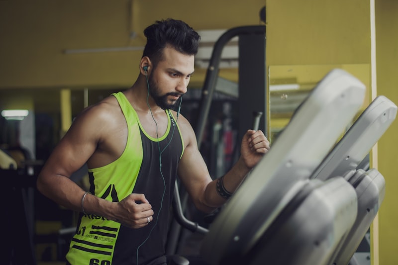 man in green tank top sitting on black chair