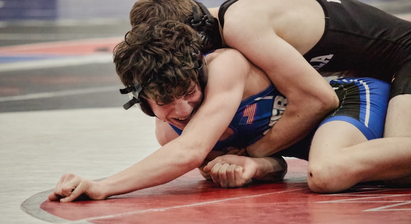 Two wrestlers grappling intensely on a mat