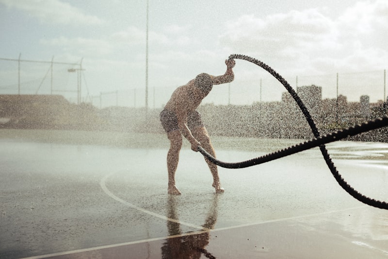 a man is playing in the water with a hose