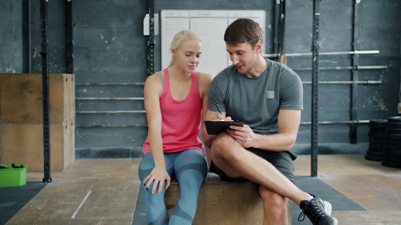 Man and woman looking at tablet in gym