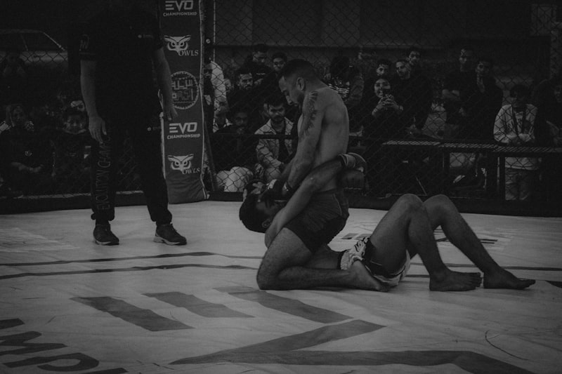 A man sitting on the ground in a wrestling ring