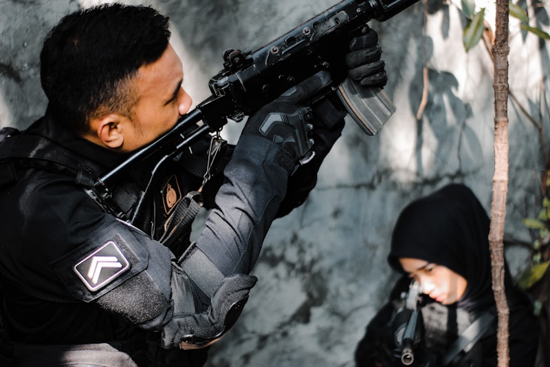 a man holding a gun and a woman looking at him