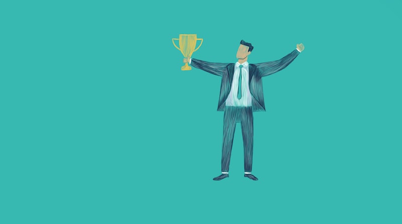 Man in suit holding a trophy with arms raised