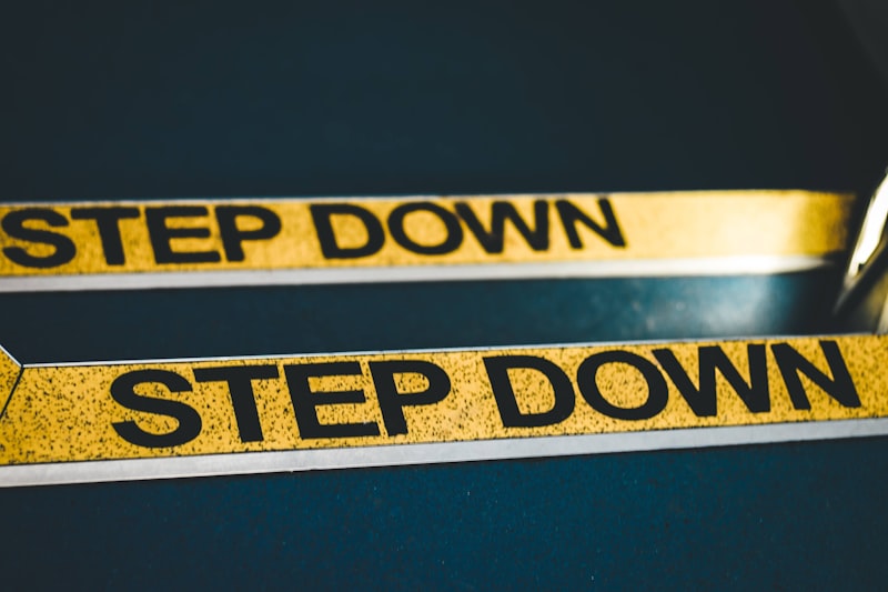 a close up of a pair of scissors near a step down sign