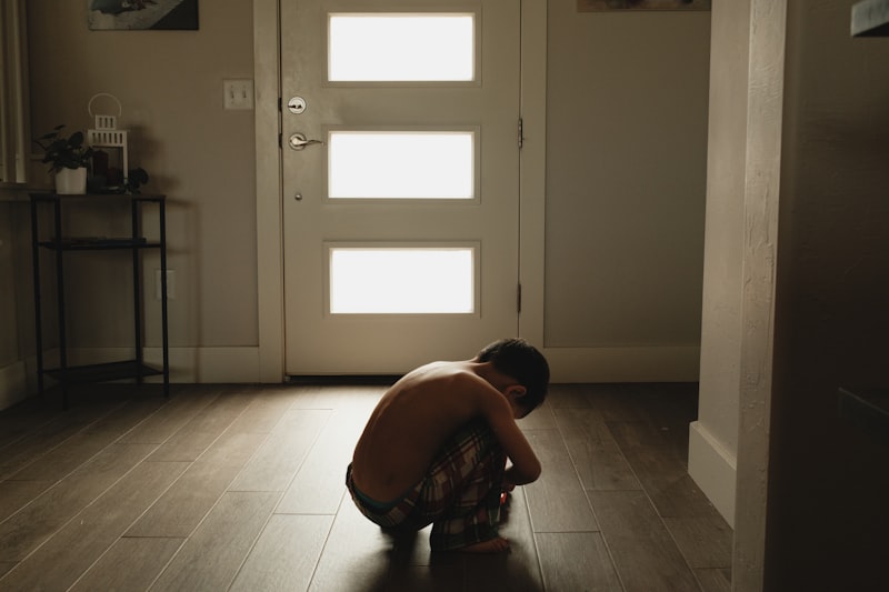 A person kneeling on the floor in front of a door