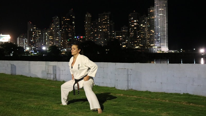 Woman in karate uniform practicing outdoors at night