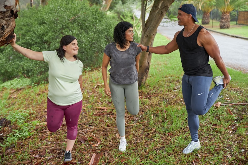 Three people stretch before a run on a rainy day