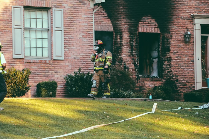 fireman walking in front of brown brick house