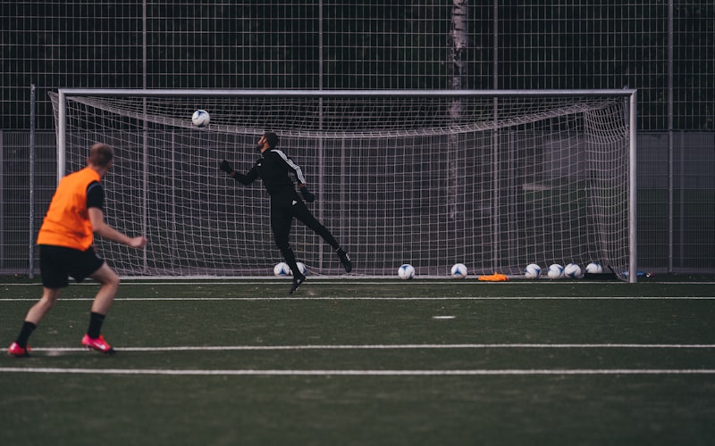 a couple of people on a field with a soccer ball