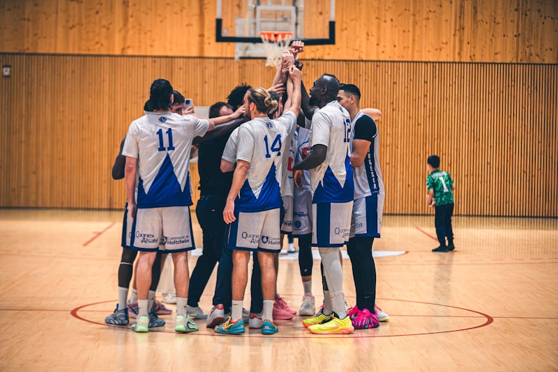 Basketball team huddles together on court