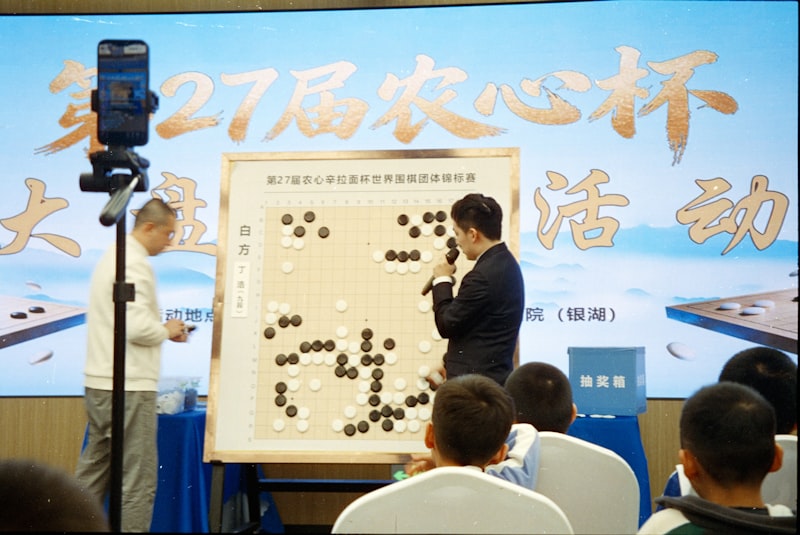 Two men playing go board game with audience watching