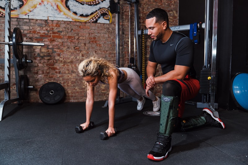 a man helping another man do push ups