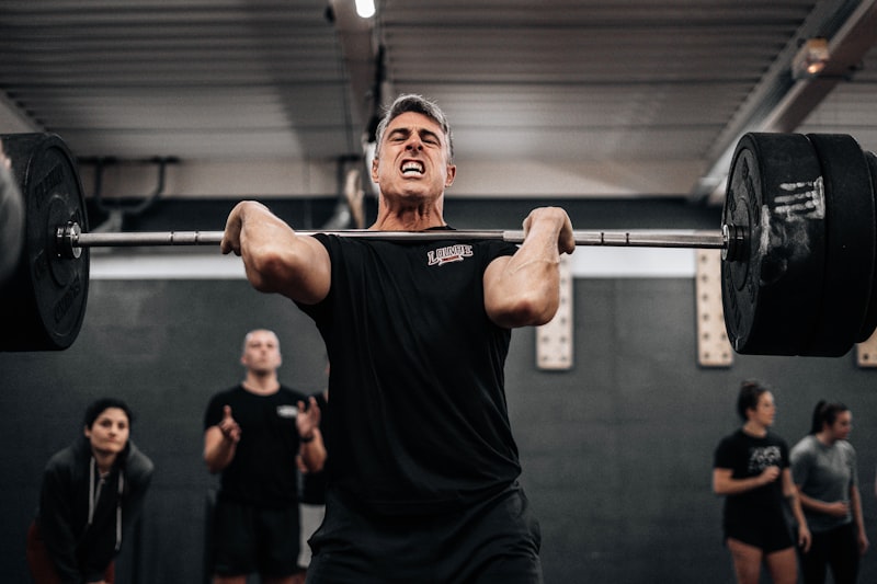 a man lifting a barbell in a gym