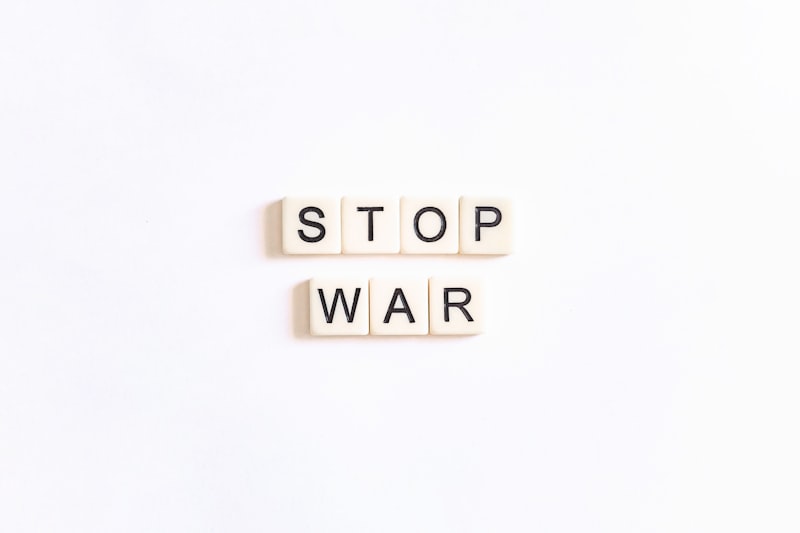 two scrabble tiles spelling stop war on a white background